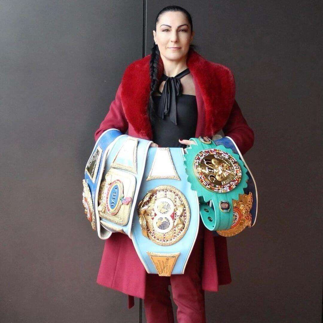Growth Media visual showcasing a successful woman embodying empowerment and leadership with championship belts.